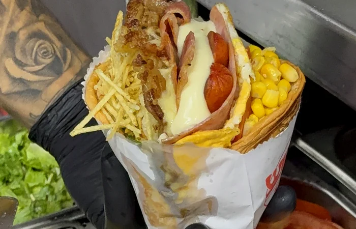 Sanduíche de pit dog Wilsu's com milho, bacon e batata palha